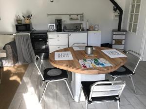 a kitchen with a wooden table and chairs at La petite Escarpolette in Arzon