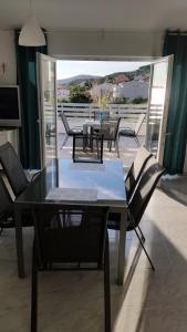 a dining room with a table and chairs on a balcony at Big Blue - Xenija (Veliko Plavetnilo - Ksenija) in Metajna