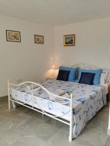 a white bed with blue pillows in a bedroom at Studio Apartment Mileta in Pitve