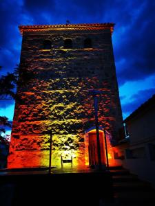 una torre del reloj con un banco delante de ella por la noche en TORREÓN DE LA TERCIA, en Consuegra