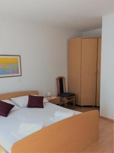a bedroom with a white bed and a cabinet at Apartman Pod Forticu in Hvar