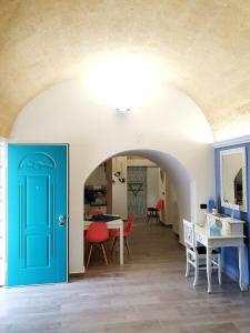 カステッラネータにあるB&B Le Volteの青いドア、テーブル、椅子が備わる客室です。
