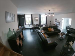 a living room with couches and a dining room at Au pied du hêtre in Tournai