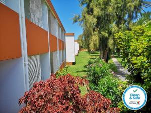 a garden next to a building with plants and trees at Hotel Porto Santo & Spa in Porto Santo