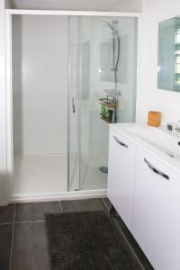 a white bathroom with a shower and a sink at CITE D'ALETH - Au pied des plages & des ports in Saint Malo