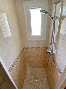 ein Bad mit einer Dusche und einem Fenster in der Unterkunft Les Gîtes in Jausiers