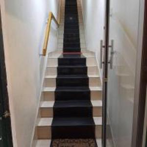 een trap met zwarte en witte trappen in een gebouw bij Emerald Inn in Brinchang