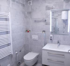 a white bathroom with a toilet and a sink at A&D Apartments in Rovinj