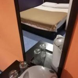 łazienka z umywalką, łóżkiem i lustrem w obiekcie Emerald Inn w mieście Brinchang