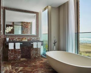 a bathroom with a tub and a large window at Four Seasons Hotel Casablanca in Casablanca
