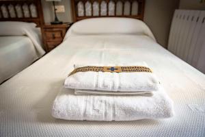 uma pilha de toalhas sentadas em cima de uma cama em A Morada do Cigarron em Verín