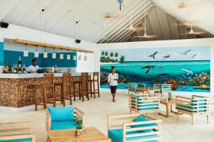 een weergave van een restaurant met een muurschildering van de oceaan bij Sun Siyam Olhuveli in South Male Atoll