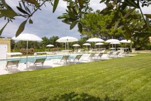 a row of chairs and umbrellas next to a pool at La Casina Di Borgagne in Borgagne