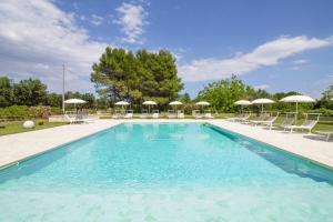 a swimming pool with chairs and umbrellas at La Casina Di Borgagne in Borgagne