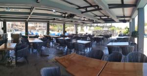 a dining room with tables and chairs and tables andwindows at Sidari Waterpark in Sidari