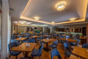 a restaurant with wooden tables and blue chairs at Kastro Maini in Areopolis