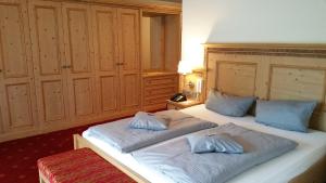 a bedroom with two beds with blue pillows on them at Landhotel Böld Oberammergau in Oberammergau