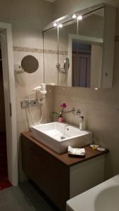 a bathroom with a white sink and a mirror at Landhotel Böld Oberammergau in Oberammergau