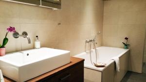 a bathroom with a white sink and a tub at Landhotel Böld Oberammergau in Oberammergau