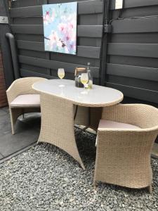 a white table and two chairs with wine glasses at gardenhouse mariposa in Badhoevedorp