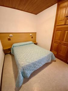 a bedroom with a bed and a wooden door at Les Gîtes in Jausiers