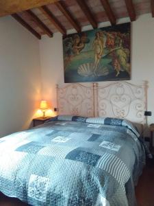 1 dormitorio con 1 cama con una pintura en la pared en Guinzano, en Gubbio
