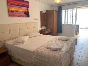 a bedroom with a large bed with two towels on it at Kassiopi Bay in Kassiopi
