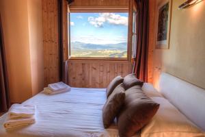 - une chambre avec un lit doté d'oreillers et d'une fenêtre dans l'établissement Villa Chimera, à Poppi