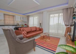 a living room with a couch and chairs and a kitchen at MULBERRY SUİT APART in Kaş