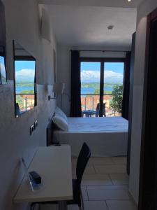 Schlafzimmer mit einem Bett und Meerblick in der Unterkunft Hotel La Locanda in Cadrezzate