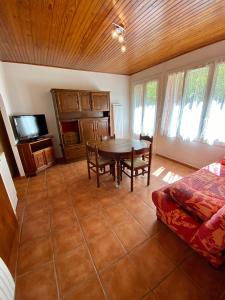 a living room with a dining room table and a couch at Les Gîtes in Jausiers