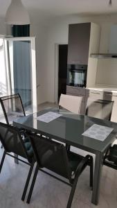 a glass table and chairs in a kitchen at Big Blue - Xenija (Veliko Plavetnilo - Ksenija) in Metajna