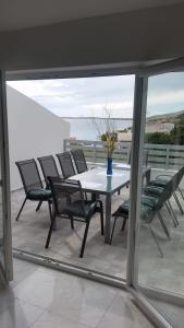 a table with chairs and a vase of flowers on a balcony at Big Blue - Xenija (Veliko Plavetnilo - Ksenija) in Metajna