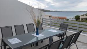 a table with chairs and a vase with flowers on a balcony at Big Blue - Xenija (Veliko Plavetnilo - Ksenija) in Metajna