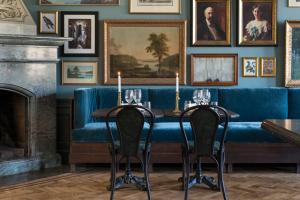 a dining room with a blue couch and a fireplace at Näsby Slott in Täby