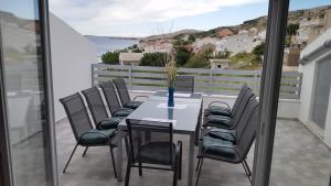 a table and chairs on a balcony with a view at Big Blue - Xenija (Veliko Plavetnilo - Ksenija) in Metajna