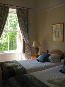 1 dormitorio con 2 camas y ventana en The Georgian House en Glasgow
