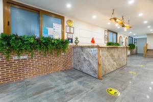 a lobby with a counter and a brick wall at Hanedan Hotel Foca Izmir in Foça