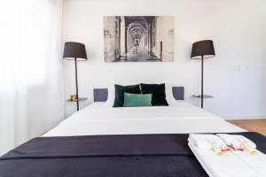 リスボンにあるIndustrial Lisbon Apartmentのベッドルーム(白い大型ベッド、ランプ2つ付)