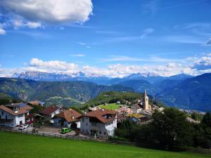 a town on a hill with mountains in the background at Sonnenparadies in San Genesio Atesino