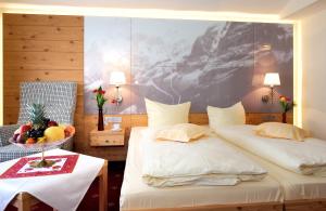 a hotel room with two beds and a bowl of fruit at Landhotel Böld Oberammergau in Oberammergau