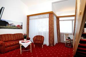 a living room with a couch and a table at Landhotel Böld Oberammergau in Oberammergau
