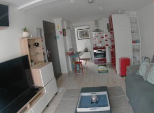 Una sala de estar con un sofá y una cocina. en LePéri5scope, en Berck-sur-Mer 14 fotos más