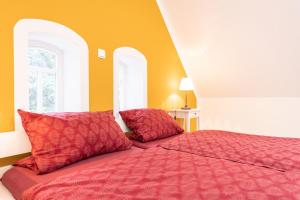 a bedroom with a red bed with two red pillows at Ramakers Hof in Kirchlinteln