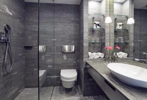 a bathroom with a toilet and a sink and a shower at Swissôtel Amsterdam in Amsterdam