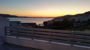 a view of the ocean at sunset from a balcony at Big Blue - Xenija (Veliko Plavetnilo - Ksenija) in Metajna