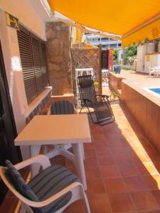 a table and chairs on a patio with a table and a table and a table at Apartamentos Sirena in Mogán