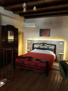 Schlafzimmer mit einem Bett mit einer roten Bettdecke in der Unterkunft Nivritos Traditional Homes in Nívritos