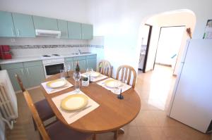 a kitchen with a wooden table and a dining room at Apartment Margareta in Njivice