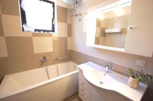 a bathroom with a sink and a tub and a mirror at Apartment Margareta in Njivice